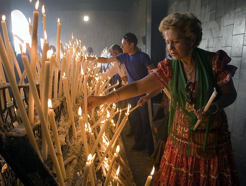 Varios romeros depositan velas en la ermita de la Virgen del Rocío.