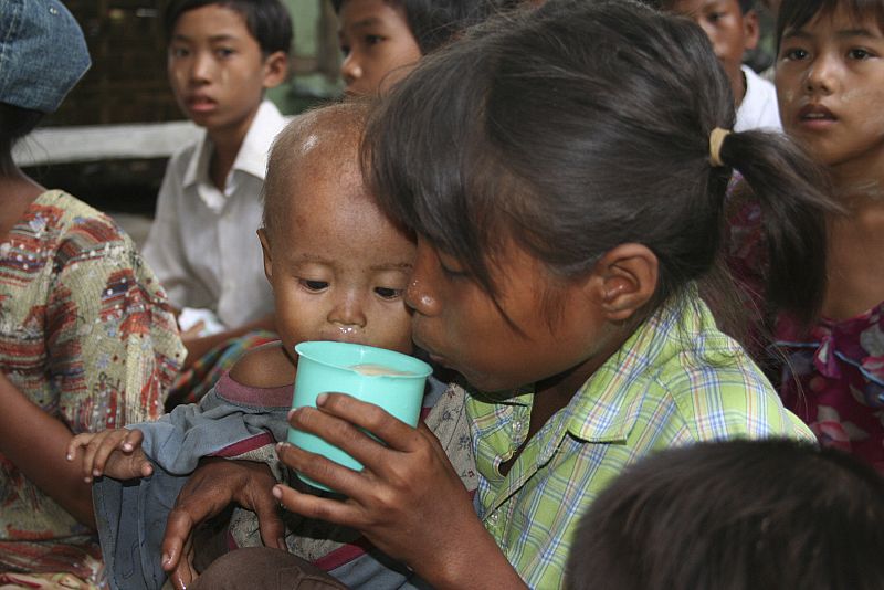 Una niña bebe leche en polvo en Birmania