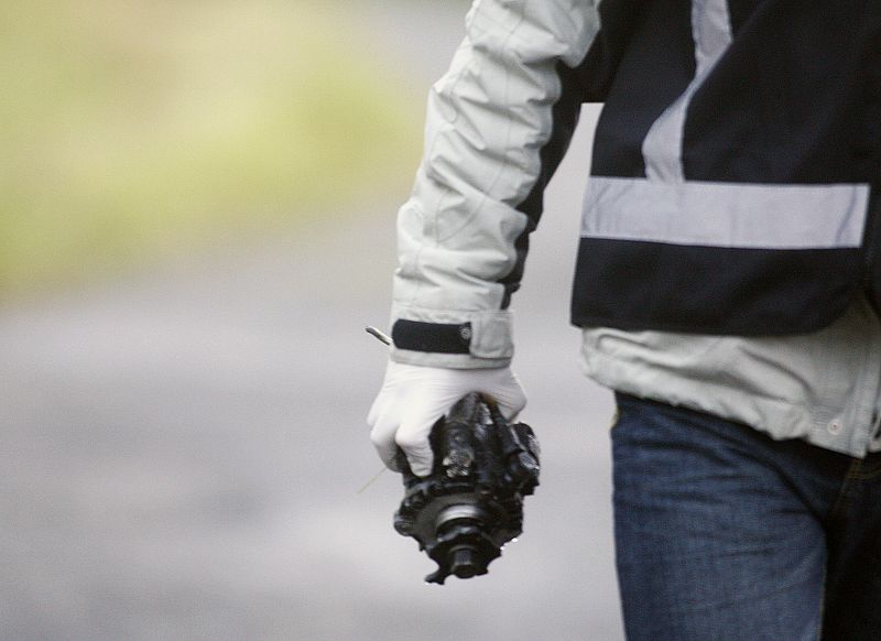 A policeman carries part of the motor of the car bomb near to the Civil Guard barracks where it exploded in Legutiano near Vitoria