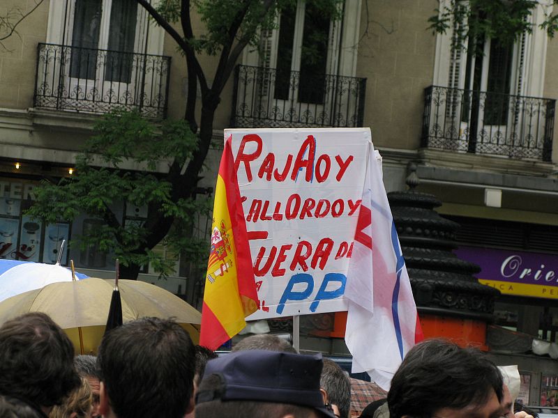 Los concentrados ante la sede del PP llevaban pancartas contra Gallardón.