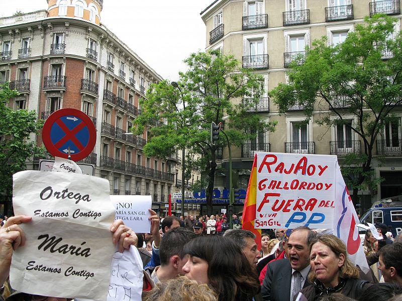 Votantes del PP llevan pancartas contra Rajoy y Gallardón ante la sede del PP.