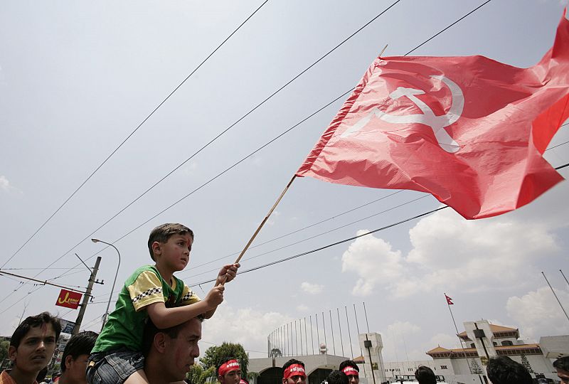 Un niño ondea una bandera comunista fuera del parlamento mientras espera que la asamblea declare la república.