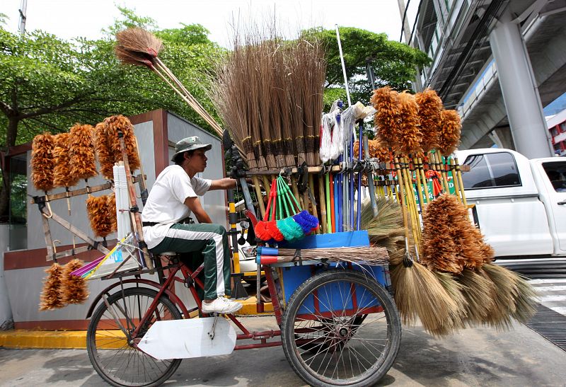 Una bicicleta con carrito donde se venden una gran variedad de escobas a los peatones y conductores, es conducida por un comerciante en una calle de Bangkok, Tailandia. El aumento de los combustibles ha causado una ola de protestas en Indonesia, mien