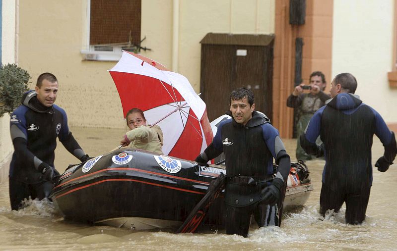 Efectivos de la Ertzaintza desaloja a una niña de un barrio de Getxo (Vizcaya) tras el desbordamiento del río Gobelas.