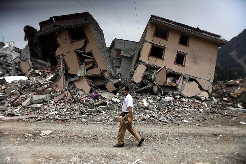 Un hombre pasea junto a las ruinas de unos edificios afectados por el terremoto de Sichuan (China).