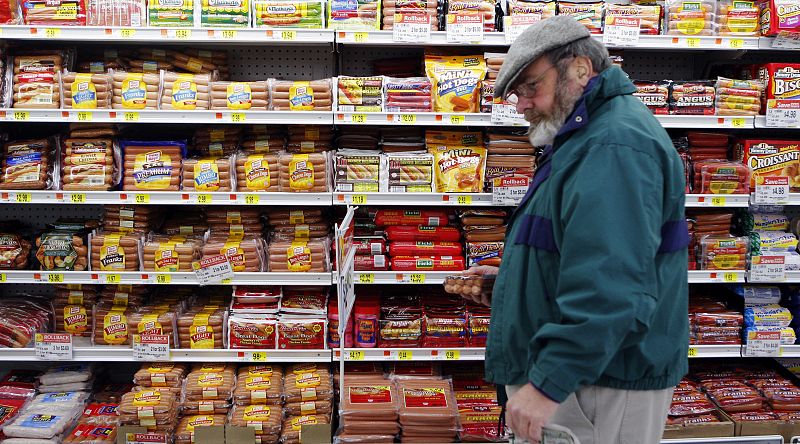 Un cliente recoge un paquete de salchichas de una estantería en un supermercado de la cadena WalMart de Crossville, Estados Unidos.