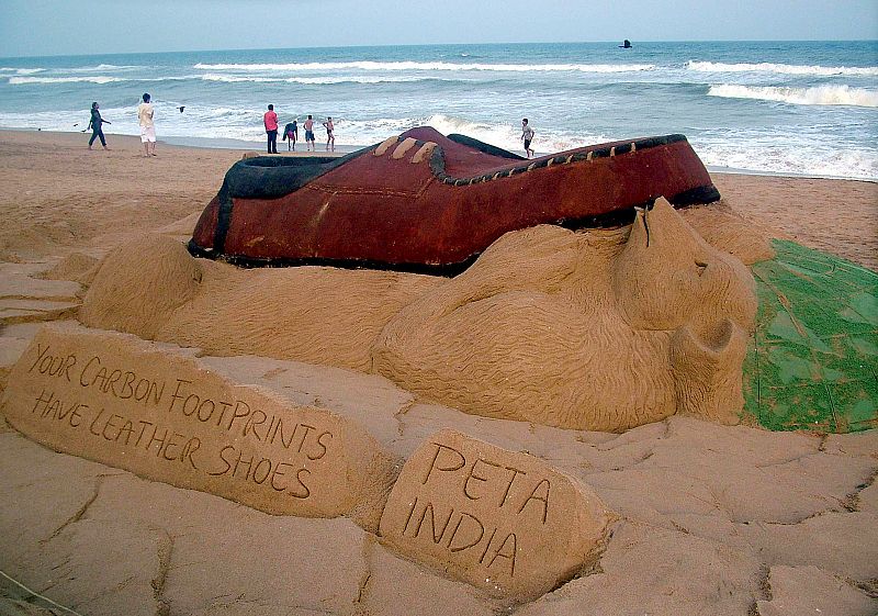 Una escultura de arena de un oso polar gigante pisado por un zapato, creación del artista Sudarshan Pattnaik, en la playa india de Puri Golden.