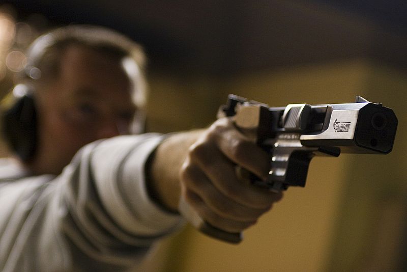 Franck Dumoulin, French Olympic 10m pistol champion in the Sydney 2000 games, takes aim during a practice session in Talence