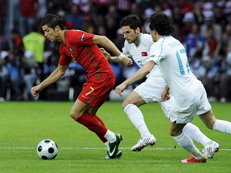 El jugador portugués Cristiano Ronaldo regatea ante los turcos Tuncay Sanli y Hakan Balta.