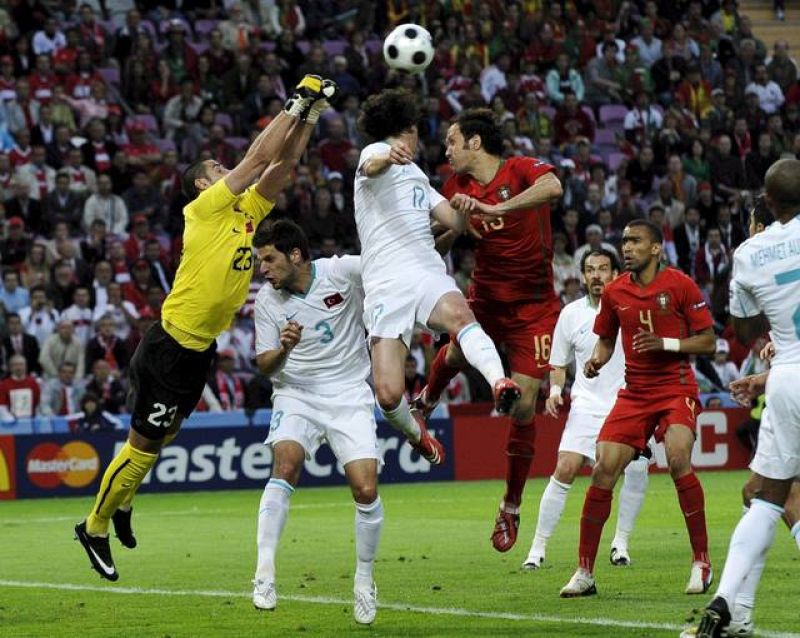 El portero turco Volkan Demirel despeja el balón en presencia de su compañero Tuncay Sanli.