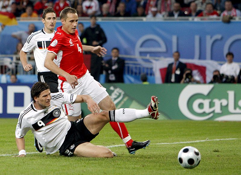 El jugador alemán Mario Gomez pelea por el control del balón con el polaco Pawel Golanski