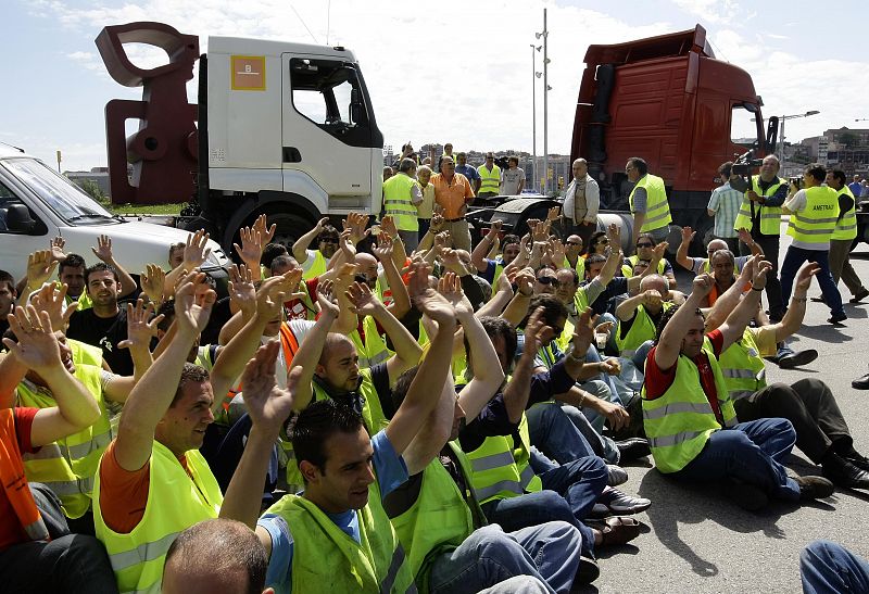 Varios camioneros catalanes hacen una sentada delante de sus camiones para bloquear la carretera en Barcelona durante la huelga de transportes.