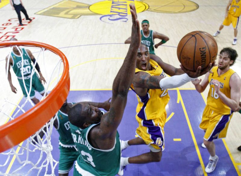 Kobe Bryant, de los Lakers, trata de encestar ante la resistencia de Perkins