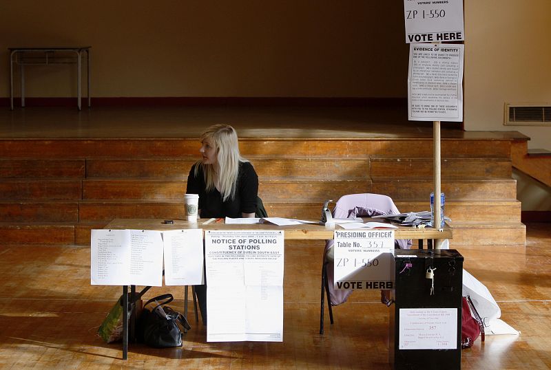 Un trabajador de un centro electoral espera a los votantes