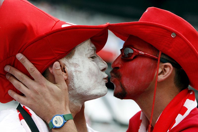 "Amor por el fútbol". Unos aficionados polacos se besan antes del comienzo del partido Croacia - Polonia.