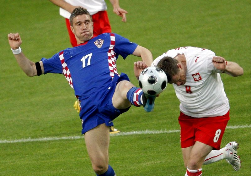 El jugador polaco Jacek Krzynowek  pelea por el control del balón con el croata Ivan Klasnic.