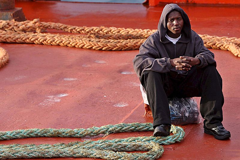 Uno de los 121 inmigrantes que viajaban en dos los dos cayucos interceptados por Salvamento Marítimo descansa a su llegada a Tenerife, tras arribar al muelle de Los Cristianos.