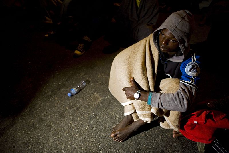 Un hombre de origen africano descansa después de que el cayuco en que viajaba llegara a Gran Canaria.