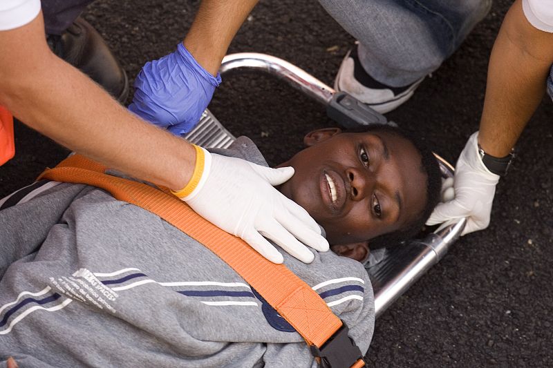 A would-be immigrant is carried on a stretcher after arriving at the port of Los Cristianos on Tenerife