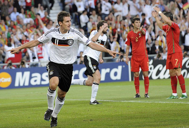 El jugador alemán Miroslav Klose celebra tras marcar el 0-2 en presencia de su compañero Christoph Metzelder y de los abatidos portugueses Paulo Ferreira y Cristiano Ronaldo .