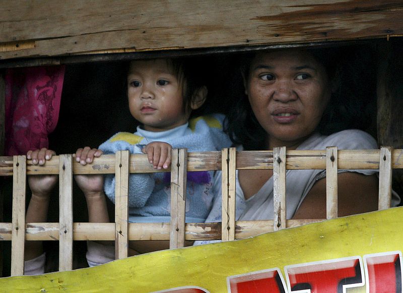 Residentes filipinos permanecen preocupados en sus casas de los barrios pobres de la ciudad como en Las Pinas, sur de Manila, Filipinas, durante las torrenciales lluvias