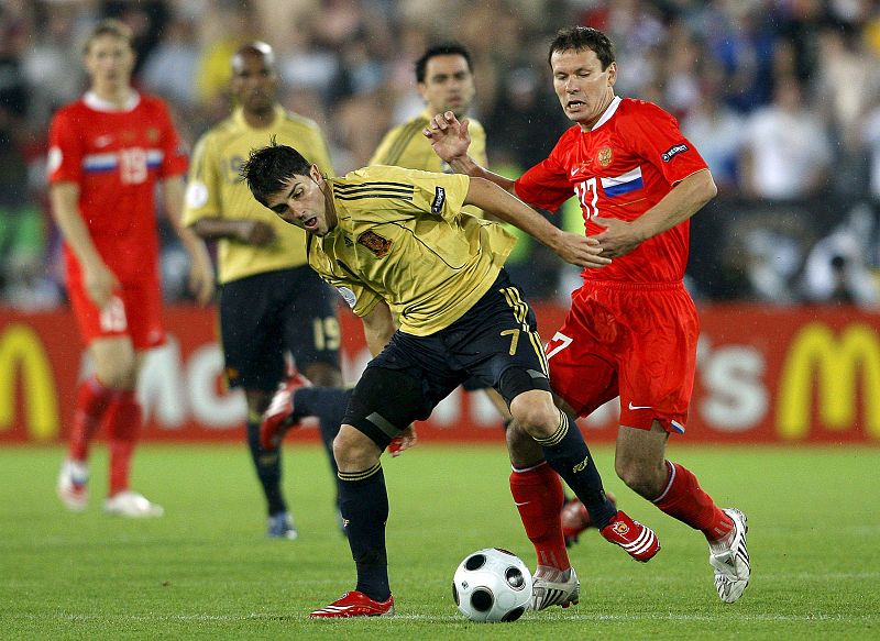 El delantero de la selección española David Villa lucha por el balón con Konstantin Zyryanov, de Rusia.