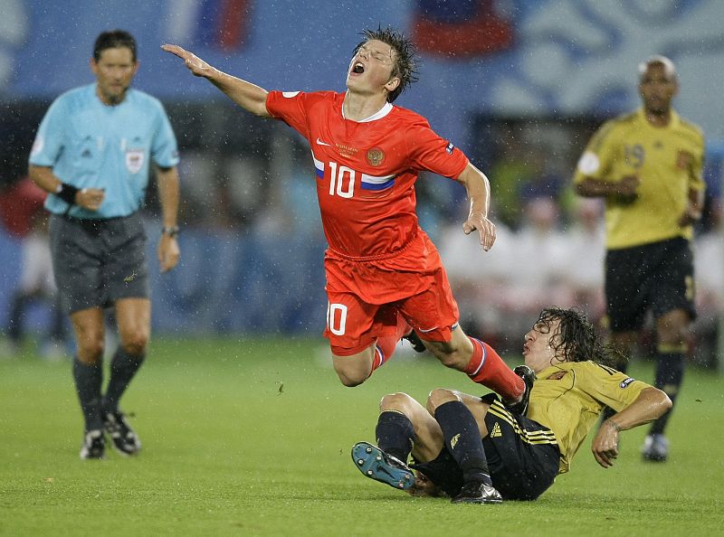 Andrei Arshavin cae ante el defensa Carles Puyol.