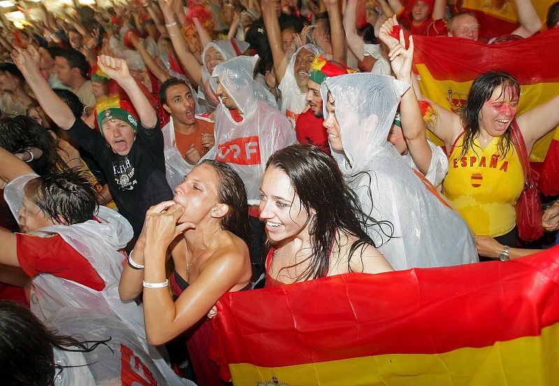 Celebración bajo la lluvia. Seguidores de la selección española de fútbol celebran la victoria por 3-0 ante Rusia en una zona pública de Viena (Austria).