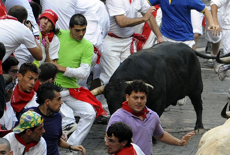 Runners are chased by a pack of Jandilla fighting bulls at the Telefonica curve on the fifth day of the running of the bulls in Pamplona