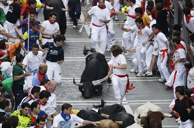 A bull falls during the fifth bull run of the San Fermin festival in Pamplona