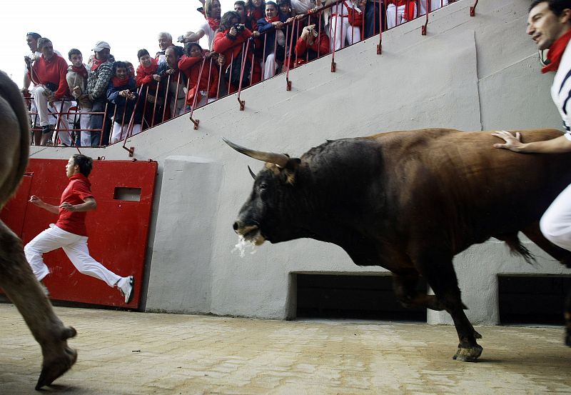 Runners are chased by Nunez del Cuvillo ranch bulls during the last bull run of the San Fermin festival in Pamplona