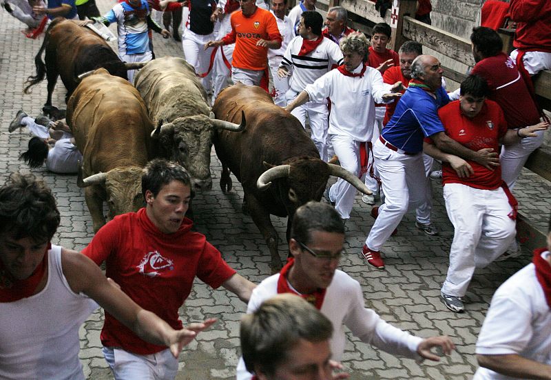 Runners are chased by Nunez del Cuvillo ranch bulls during the last bull run of the San Fermin festival in Pamplona