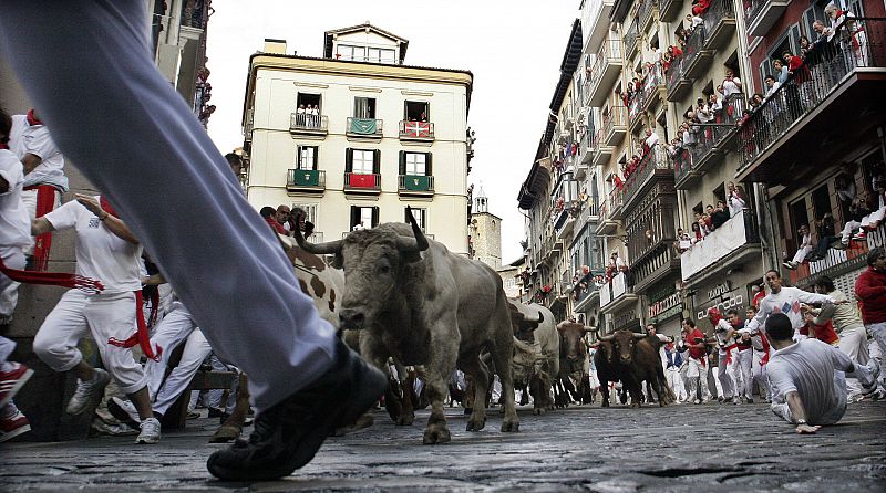 Runners are chased by a pack of Nunez del Cuvillo fighting bulls on the last day of the running of the bulls at the San Fermin festival in Pamplona.