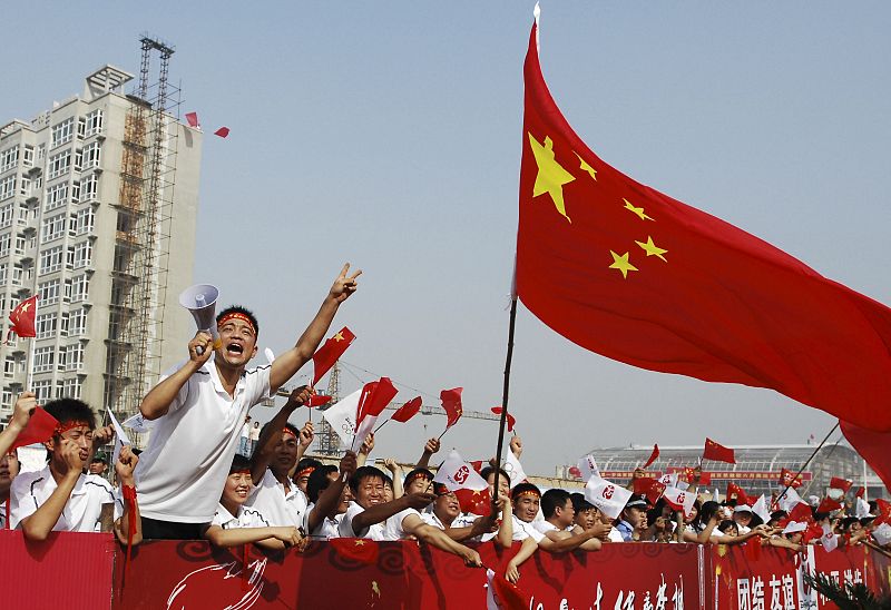 Ciudadanos ondeando banderas y dando la bienvenida a la antorcha olímpica en Yuncheng (China)