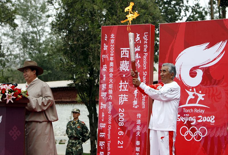 El primer relevista, el montañero tibetano Gonpo, sujeta la antorcha durante la ceremonia de relevo