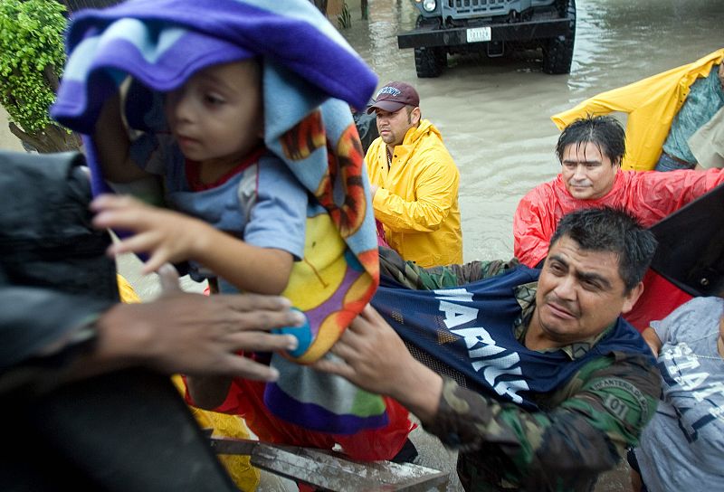 Miembros de la Marina mexicana evacuan a una familia en la ciudad de Matamoros, estado de Tamaulipas (México) fronterizo con EE.UU., donde el huracán "Dolly" ha golpeado.