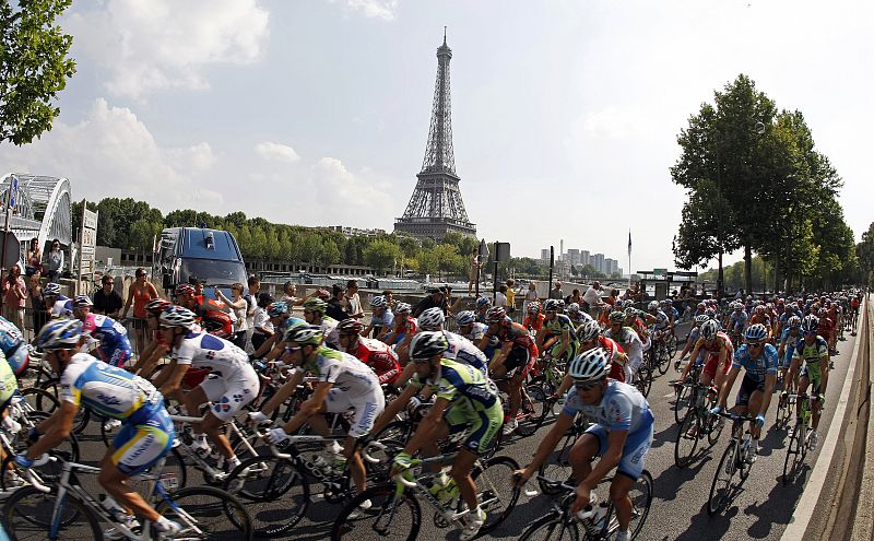 El pelotón a su paso por el río Sena, en París, con la torre Eiffel de fondo.