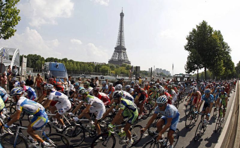 El pelotón a su paso por el río Sena, en París, con la torre Eiffel de fondo.