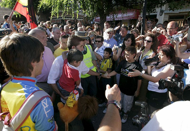 El vencedor de esta edición del Tour de Francia, Carlos Sastre, con su hijo Yeray en brazos, saluda a sus vecinos de El Barraco (Ávila).