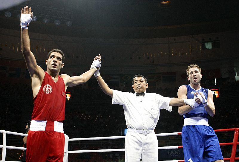 Referee Somchai declares Moussaid of Morocco the winner in his men's light welterweight (64kg) Round of 32 boxing match against Kidd of Australia in Beijing