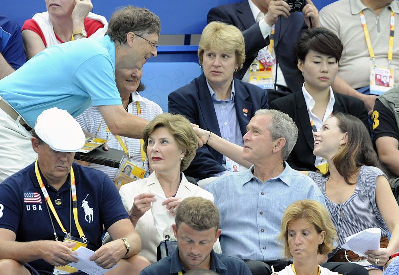 Microsoft co-founder Bill Gates shakes hands with Barbara Bush as U.S. President George Bush and first lady Laura Bush watch the swimming events at the National Aquatics Center during the Beijing 2008 Olympic Games