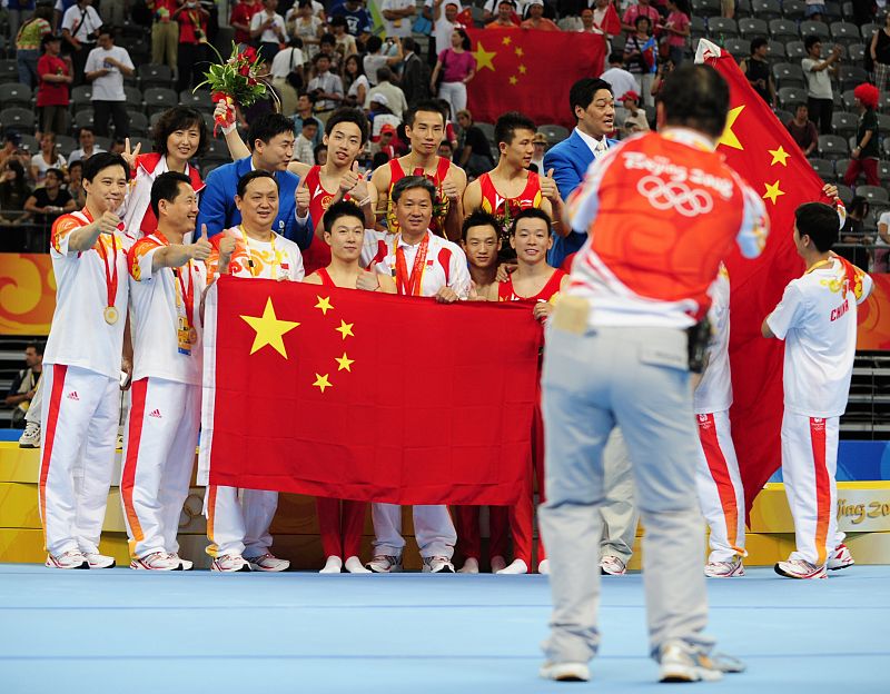 Members of the Chinese team pose for a picture after the medal ceremony for their men's team artistic gymnastics gold medal at the Beijing 2008 Olympic Games