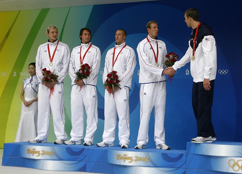 Phelps of the U.S. shakes hands with Leveaux of France during the medal presentation ceremony after the men's 4x100m freestyle relay final at the Beijing 2008 Olympic Games