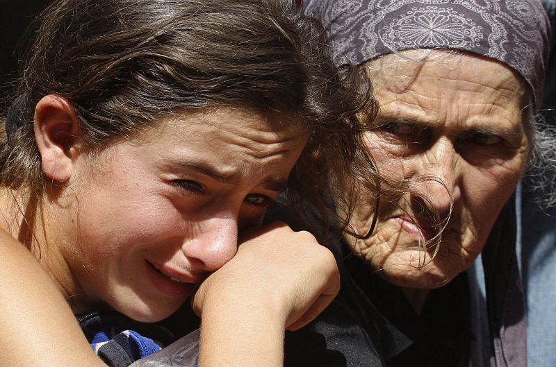 Una niña y una anciana dejan la ciudad de Gori, en Georgia, país que acusa a Rusia de no abandonar la ciudad a pesar del alto el fuego.