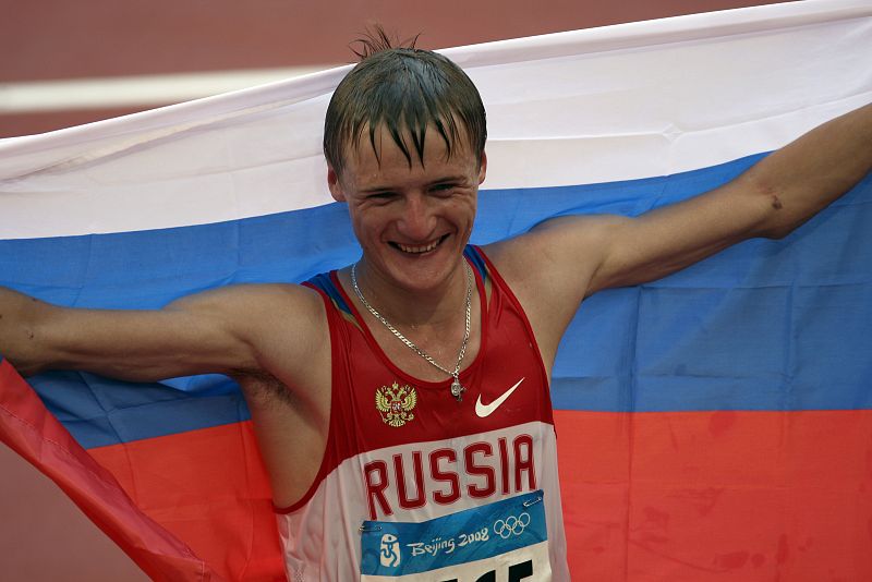 El ruso Valery Borchin con una bandera de su país tras ganar la prueba de los 20 kilómetros marcha de los Juegos Olimpicos de Pekín.