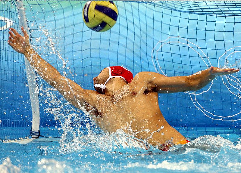 El portero montenegrino Zdravko Radic no logra para un tiro de un jugador español durante el partido de la ronda preliminar del grupo A que se disputó en el centro acuático de deportes olímpicos Yingdong en Pekín.