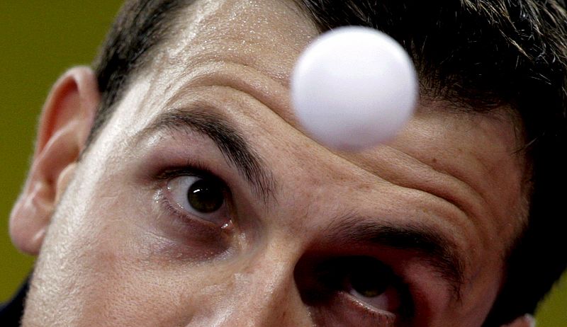 El alemán Timo Ball en acción frente al japonés Jun Mizutani en el partido masculino de Tenis de Mesa disputado en el Gimnasio de la Universidad de Pekín.