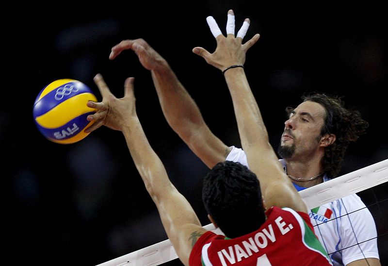 El jugador italiano Vigor Bovolenta remata el balón ante el bloqueo del búlgaro Evgeni Ivanov durante el partido del grupo A de la competición masculina de voleibol de los Juegos Olímpicos.