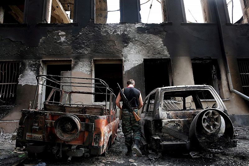 Un soldado pasa frente a carros destruídos en una de las calles de Tskhinvali (Georgia). Las autoridades de Osetía del Sur declararon que aproximadamente el 80 por ciento de la población abandonó la localidad tras el ataque de Georgia.