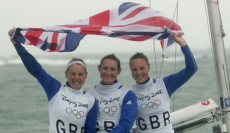 Las regatistas británicas Sarah Ayton, Sarah Webb y Pippa Wilson celebran la medalla de oro que ganaron en la final femenina de la categoría Yngling femenino en el campo de regatas de Qingdao.